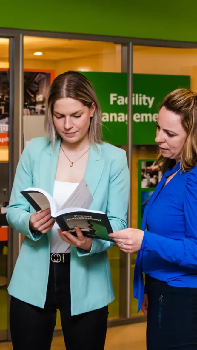 Facility Management - studenten bladeren in boek