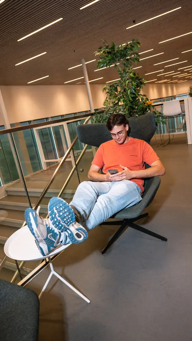 Applied Science - student met telefoon in luie stoel