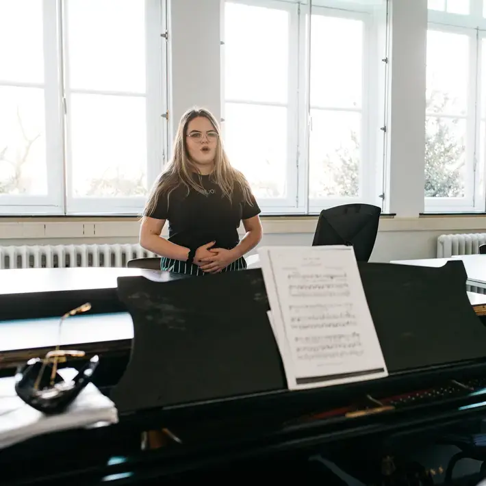 Docent Muziek - meisje zingt naast piano