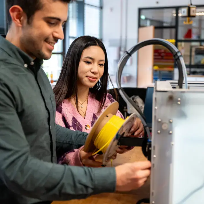 Engineering - studente met roze trui bij apparaat