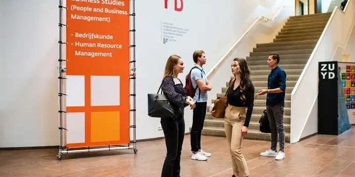Business Studies - vier studenten bij trap