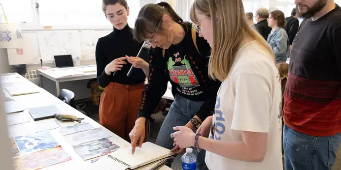 Visuele Communicatie - docent kijkt naar werk van studenten